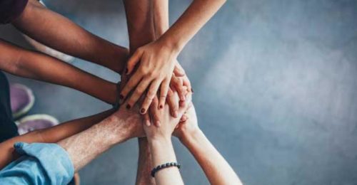 image of group of hands stacked together GO TEAM